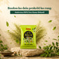 A bright lime green packet of Keshratna Pure Henna Mehendi is displayed on a stone slab with green leaves and powder splashes around it. Hindi promotional text is visible at the top, and a small bowl of henna powder sits in the lower left.